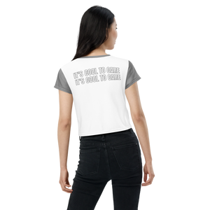Model in white cropped tee with grey sleeves, neckline, and "IT'S COOL TO CARE" large text at back.