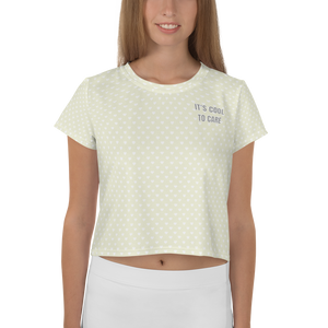 Model in beige short-sleeve cropped t-shirt with white mini polka dot heart print & grey "IT'S COOL TO CARE" text at left pocket