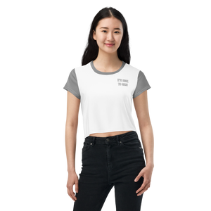 Model in white cropped tee with grey sleeves, neckline, and "IT'S COOL TO CARE" small text at left pocket area